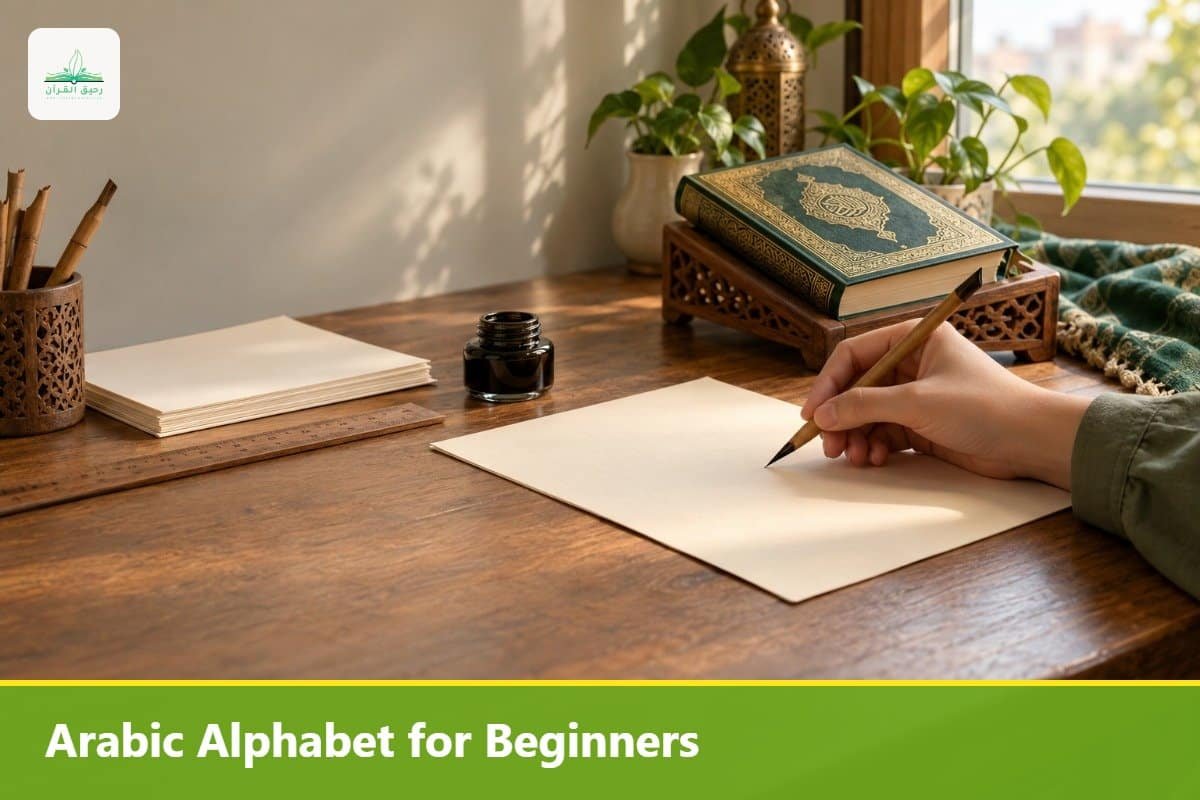 Hand with a reed pen over blank paper beside a Quran, ready to learn the Arabic alphabet